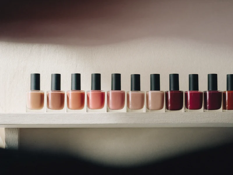 Reihe unbeschrifteter Nagellackflaschen in Nude-, Rosé- und Burgundertönen